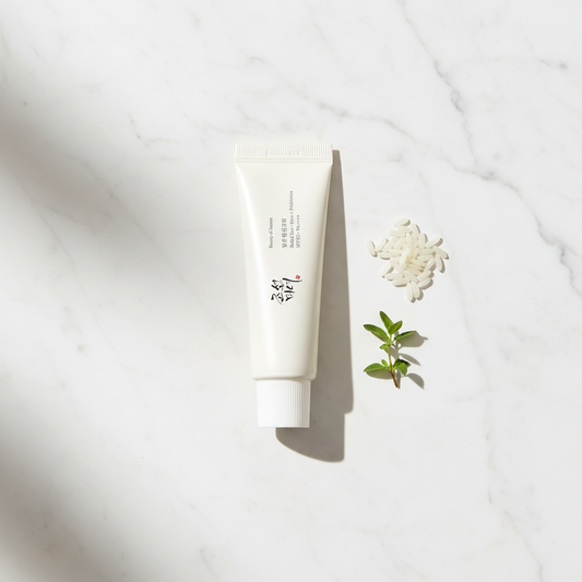 Beauty of Joseon Relief Sun SPF50+ lifestyle flat lay on marble with rice grains